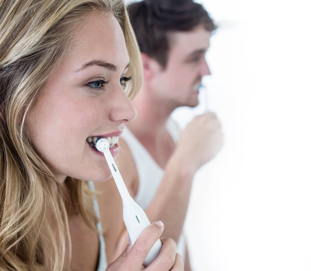 Photo of a couple brushing their teeth